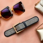 Flat lay of authentic 2003 fashion accessories including oversized square sunglasses with colored lenses, rhinestone-studded belt, and small metallic handbag on soft velour background, photorealistic styling