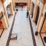 Overhead view of luxury fashion boutiques with marble flooring and modern storefronts displaying designer collections in warm Scottsdale afternoon light