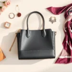 Flat lay of luxury fashion items including designer handbag, silk scarf, and premium jewelry arranged on neutral background with soft natural lighting, high-end subscription box aesthetic