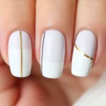Minimalist nail art featuring clean geometric lines, negative space design, monochromatic palette with single gold accent line on natural nails, professional manicure photography