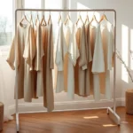 Scandinavian minimalist clothing rack featuring neutral tones, high-quality fabrics, oversized silhouettes, clean lines, natural lighting from large windows, wooden flooring, serene aesthetic reflecting Nordic design philosophy