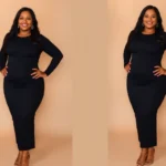 A confident plus-size woman wearing a fitted black bodycon midi dress with strategic side ruching, standing with hands on hips, wearing heeled sandals and layered gold necklaces, natural lighting, soft smile, warm studio background