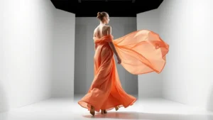 High-fashion model walking in flowing gown with dynamic fabric movement, professional lighting, modern minimalist background, showcasing elegant draping and silhouette